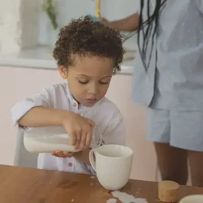 Child Pouring Milking into Glass