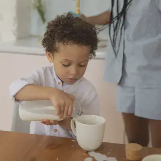 Child Pouring Milking into Glass
