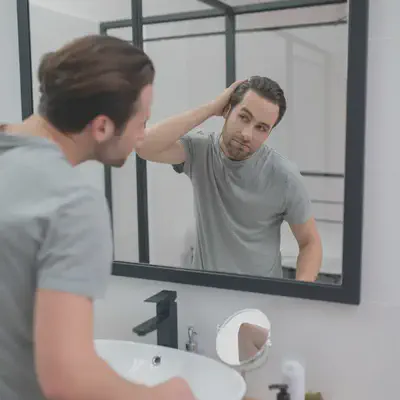 Man Looking at Self in Mirror